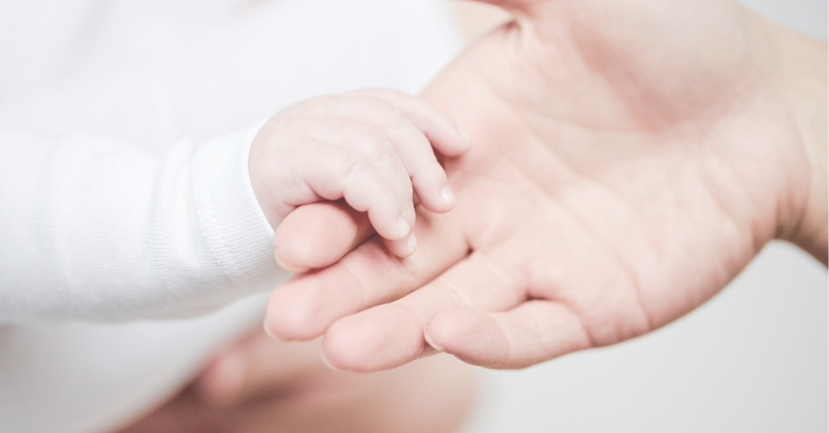 Baby's hand holding a woman's hand