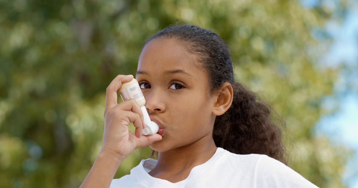 Young girl using inhaler