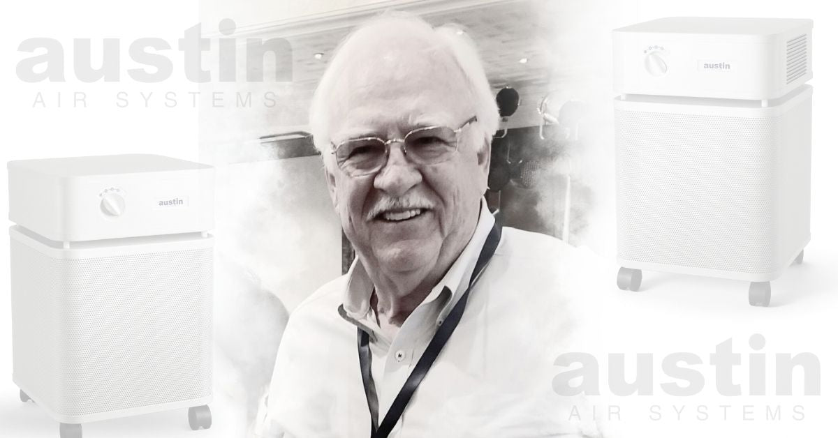 A black and white photo of Richard Taylor, a man with white hair and glasses. He was the inventor and founder of Austin Air. The photo is flanked by translucent images of Austin Air Purifiers and the Austin Air logo.
