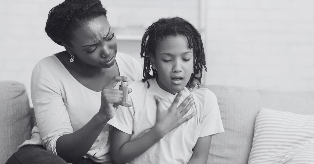 Concerned mother with daughter sitting together as daughter is struggling to breathe