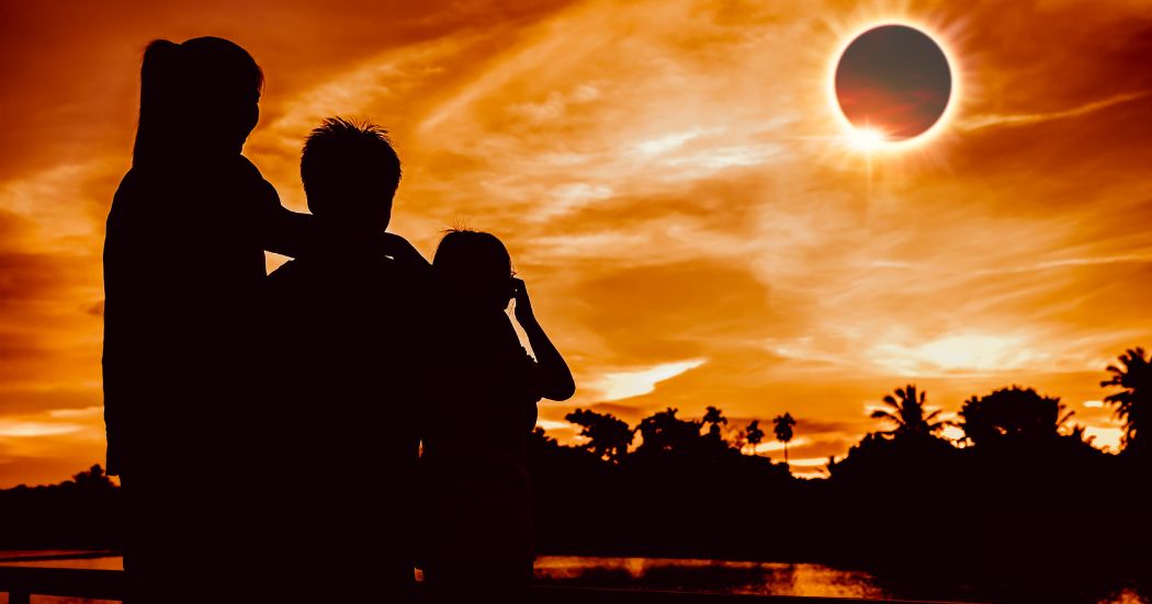 Silhouette of a family watching a solar eclipse