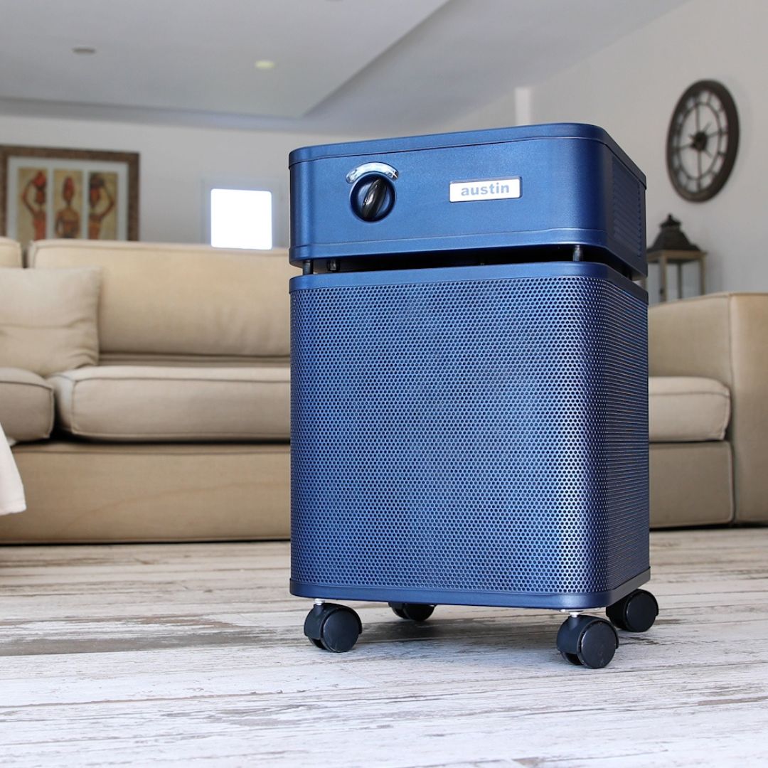 Blue air purifier on a wooden floor with a living room background