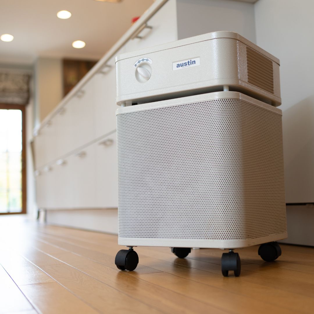 Austin Air HealthMate air purifier on a wooden floor in a room.