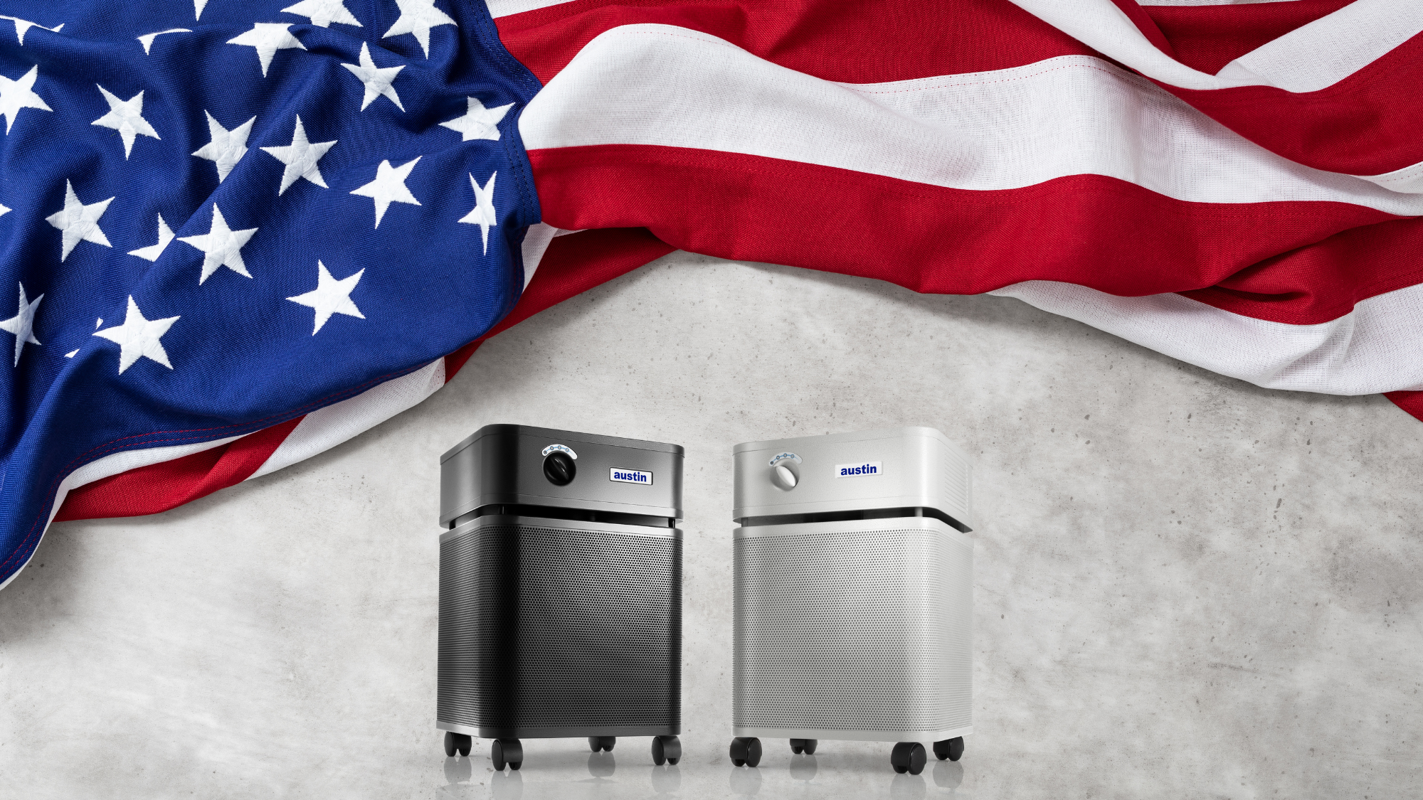 Two air purifiers on a concrete surface with an American flag in the background