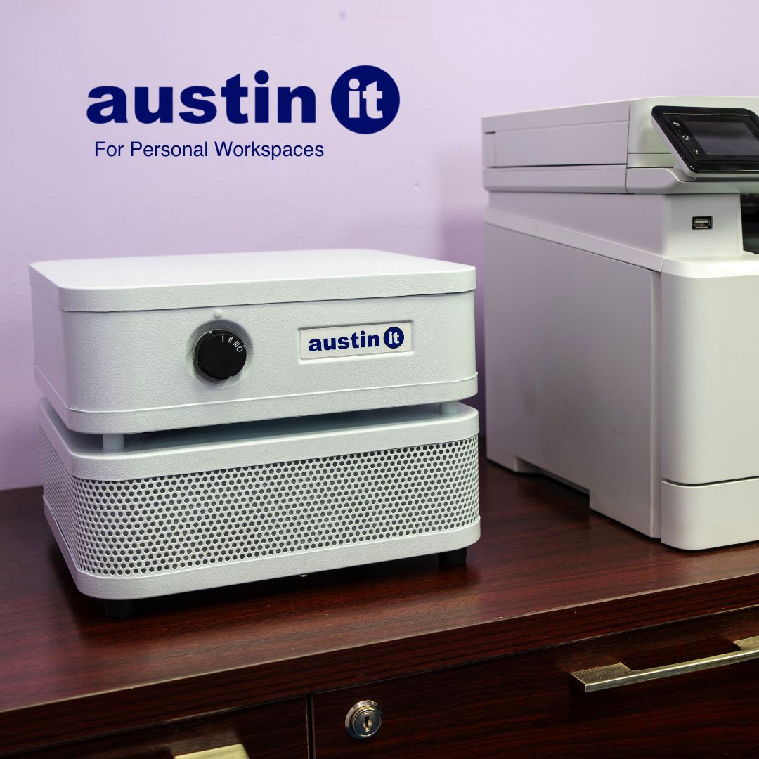 Austin air "it" with 'austin it' branding on a desk against a purple wall.