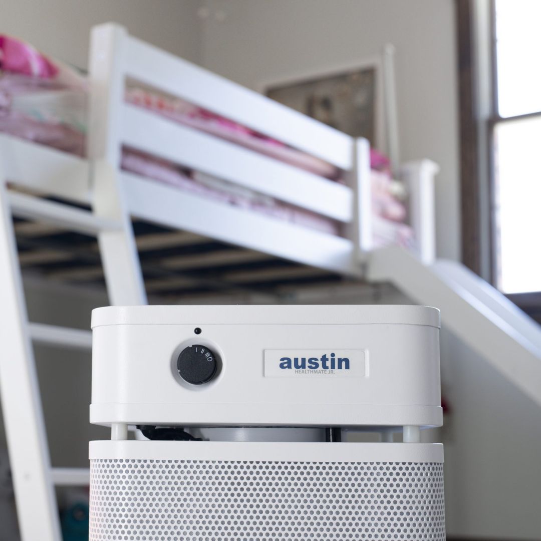 austin air healthmate junior white air purifier with 'austin' branding in a room with bunk beds.