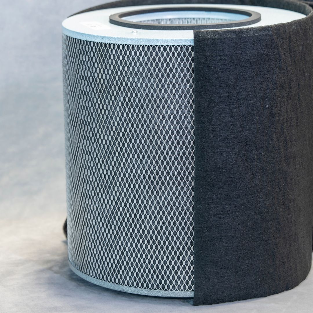 Cylindrical air filter with a black exterior and white interior on a light gray background