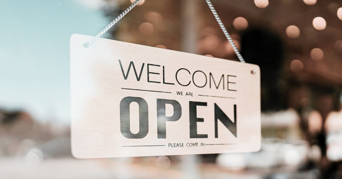 Shop window sign that says 'Welcome We Are Open"