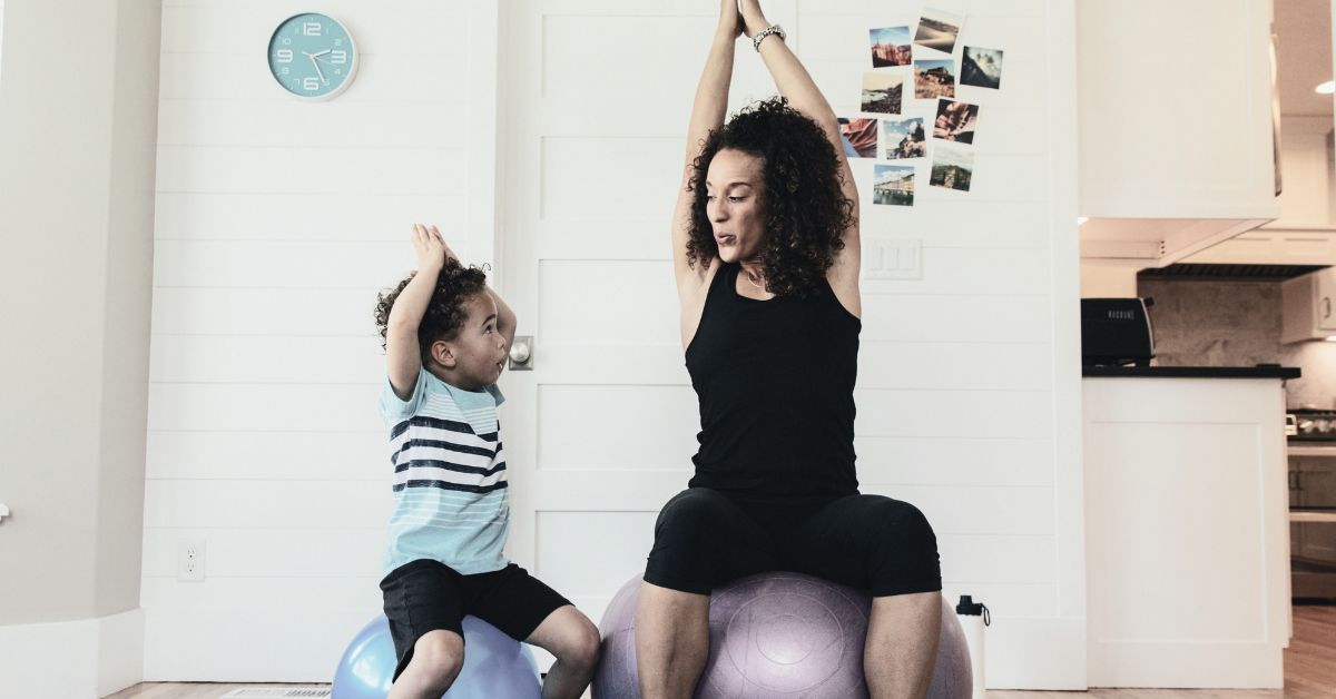 Adult and child practicing yoga on exercise balls