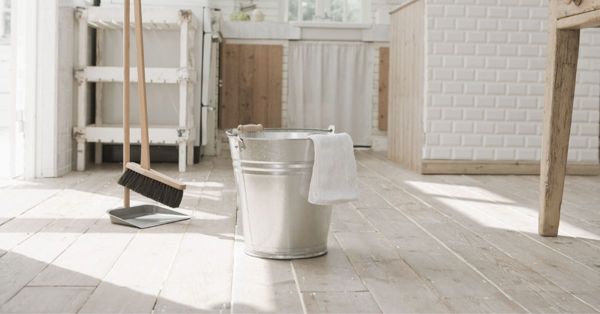 Cleaning bucket, brush and shovel on a kitchen floor