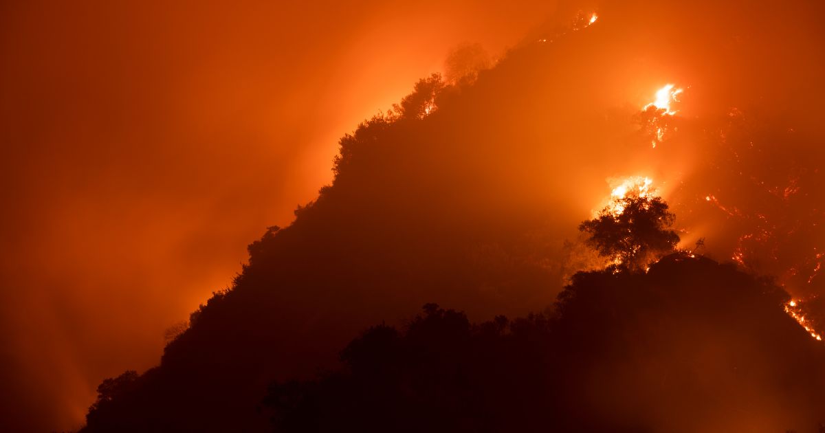Wildfires burning a mountainside 