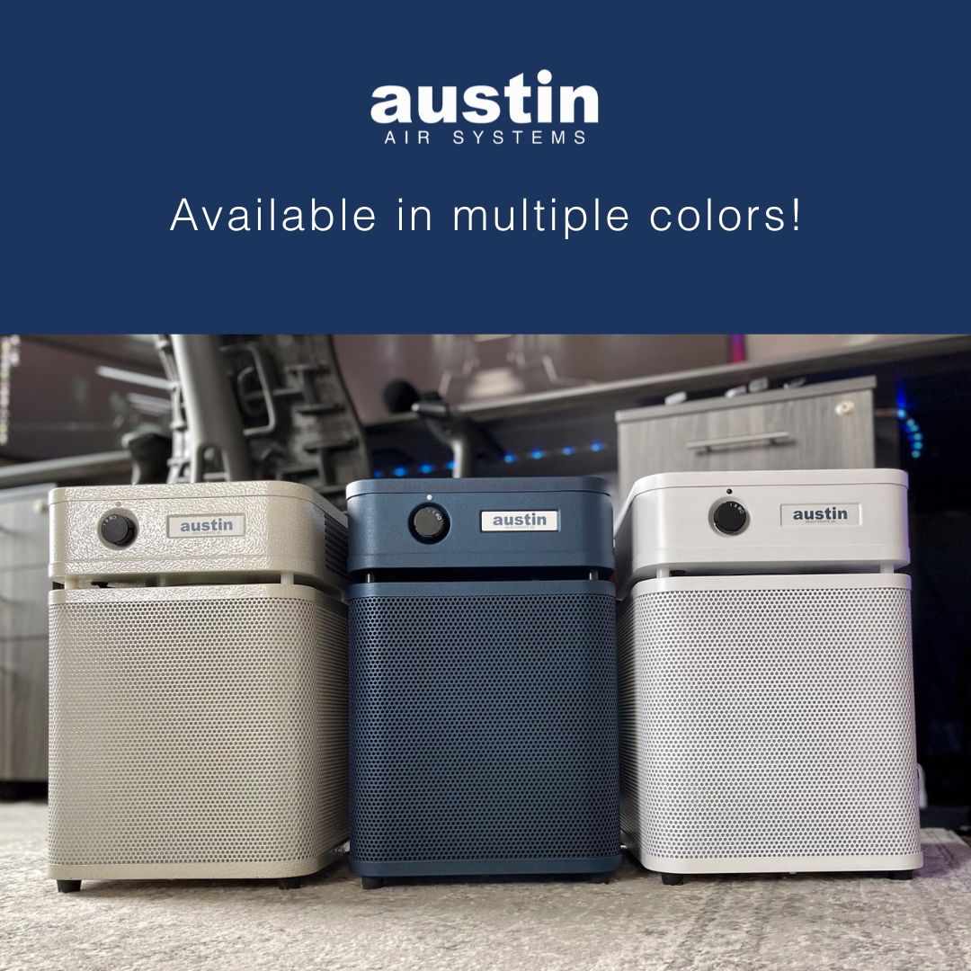 Three Austin Air HealthMate Junior purifiers in different colors on a carpeted floor with a blue banner at the top.