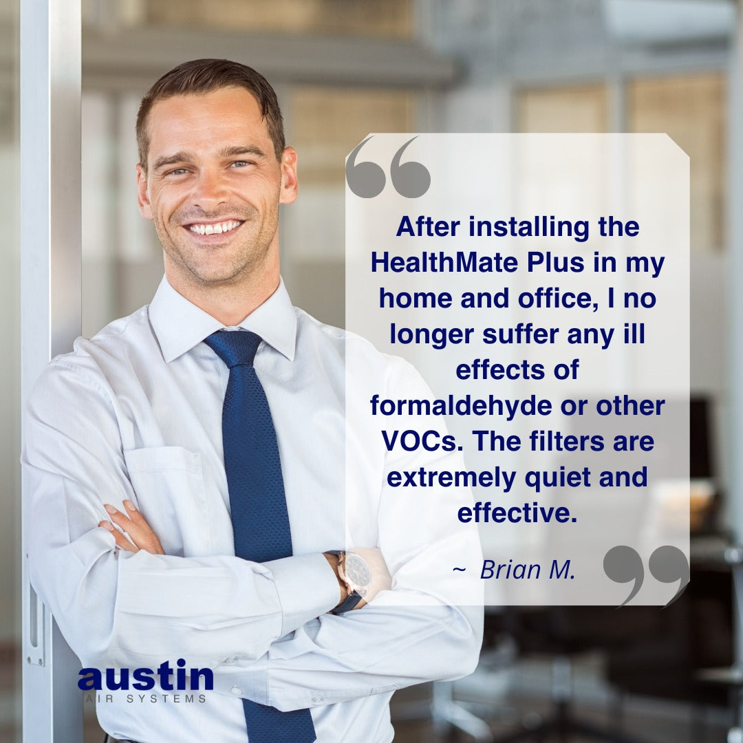 Man in a white shirt and blue tie standing in an office with a testimonial about the HealthMate Plus air filter.