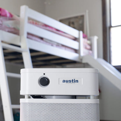 austin air healthmate junior white air purifier with 'austin' branding in a room with bunk beds.