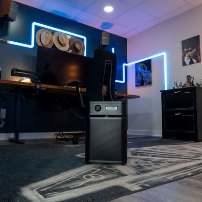 Computer setup on a desk with neon lights in a room with the healthmate plus junior